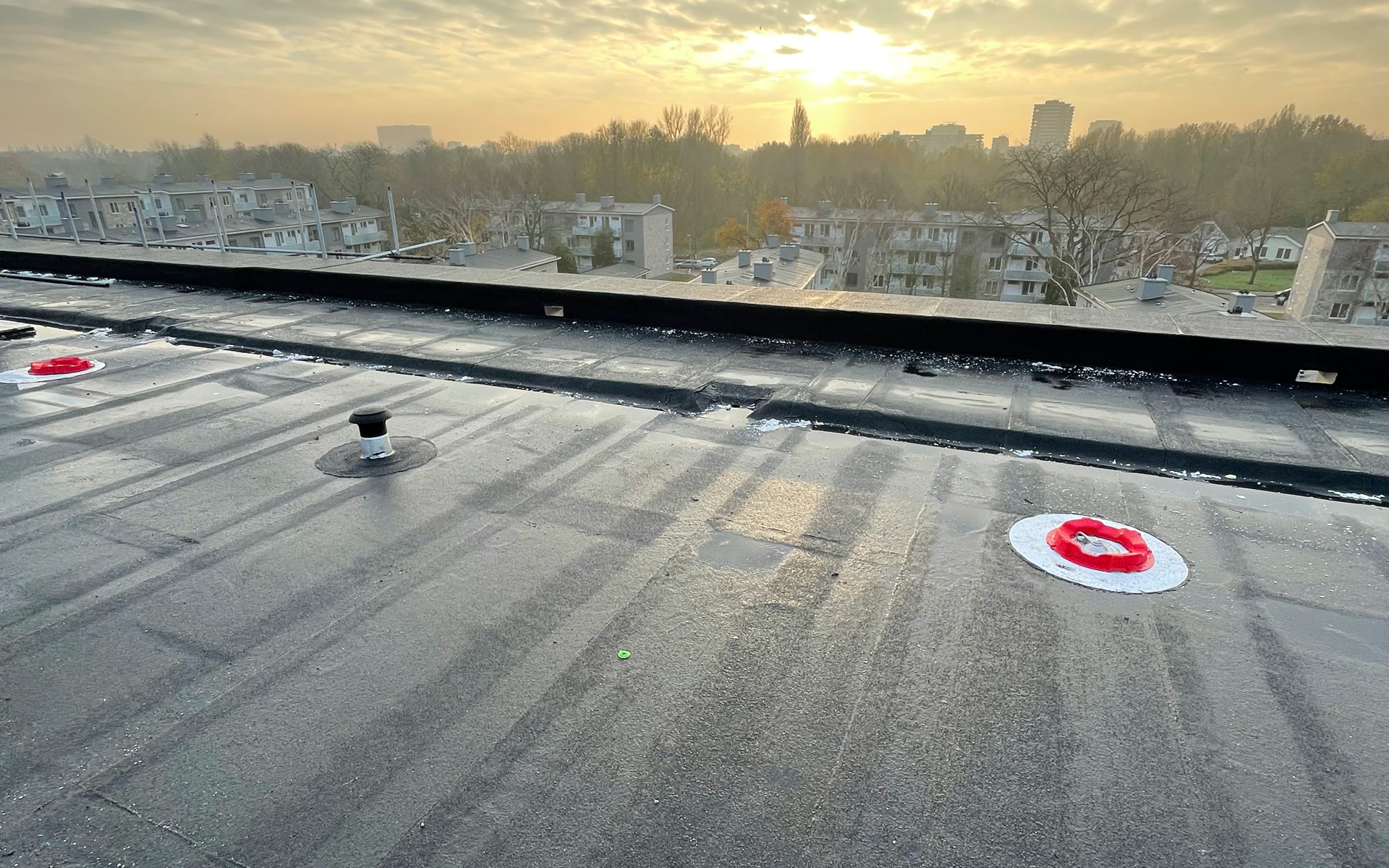Afgerond plat dak bij zonsopkomst met uitzicht over de stad